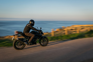 motociclista en carretera costera
