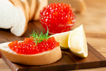 red caviar in glassware on a wooden background in a rustic style with space for text