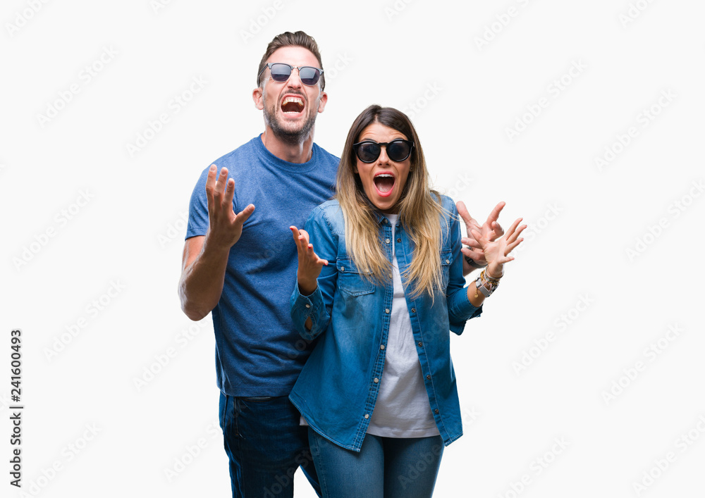 Wall mural young couple in love wearing sunglasses over isolated background celebrating mad and crazy for succe