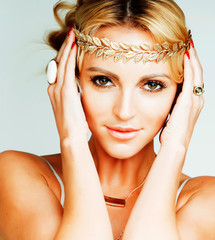 young blond woman dressed like ancient greek godess, gold jewelr