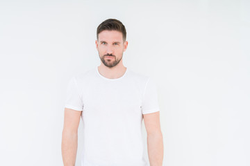 Young handsome man wearing casual white t-shirt over isolated background skeptic and nervous,...