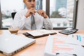 businessman working on office desk, looking tired.
