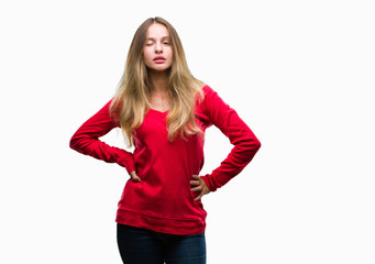 Young beautiful blonde woman wearing red sweater over isolated background winking looking at the...