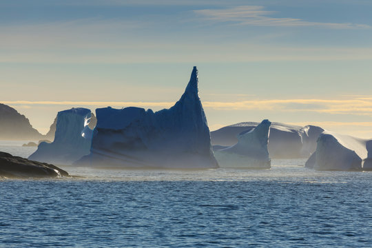 Icebergs and sea mist, entrance to Skjoldungen Fjord, early morning, King Frederick VI Coast, remote South East Greenland, Denmark