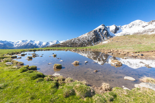 Snowy peaks reflected in the alpine lake, Motta di Olano, Valgerola, Valtellina, Sondrio province, Lombardy
