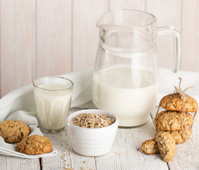 Oatmeal cookies with milk on tray on rustic wooden table