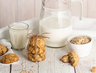 Oatmeal cookies with milk on tray on rustic wooden table