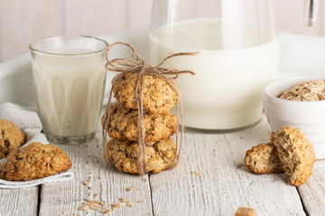 Oatmeal cookies with milk on tray on rustic wooden table