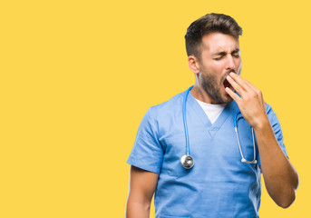 Young handsome doctor surgeon man over isolated background bored yawning tired covering mouth with...