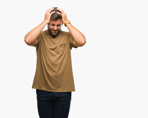 Young handsome man over isolated background suffering from headache desperate and stressed because pain and migraine. Hands on head.