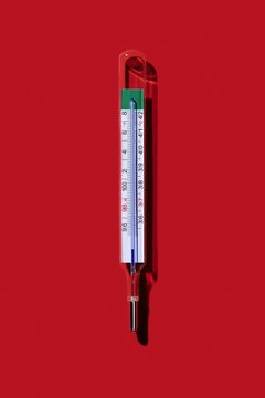 Thermometer isolated against red background