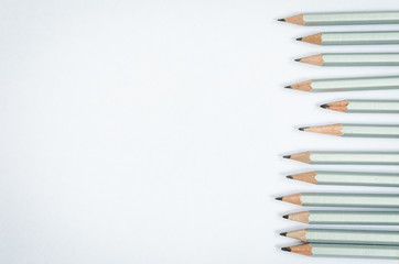 Wooden silver pencils on white paper