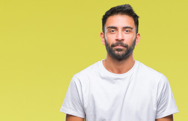 Adult hispanic man over isolated background with serious expression on face. Simple and natural looking at the camera.