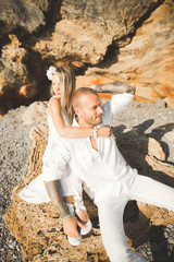 Just married wedding couple walking on the beach at sunset.