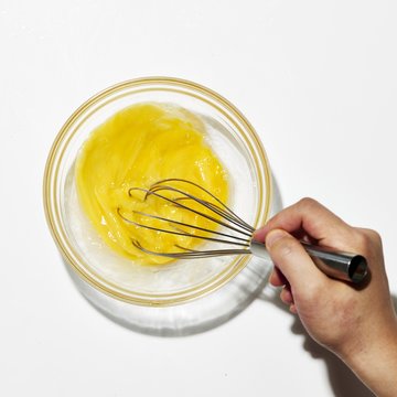 Close up of woman's hand stirring egg yolk