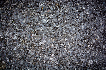 Asphalt paved road texture top view background. The texture of black stone surface (minerals) crumb. Black abstract background with defocused area.