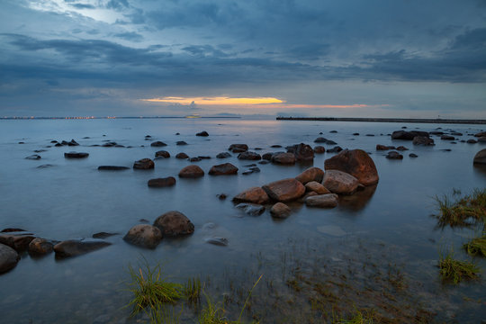 Blue hour over the sea rocky shore. Long exposure shot.