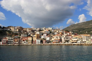 Fototapeta na wymiar View of the Greek seaside traditional town of Parga in the Ionian sea at the mediterranean in Greece in the afternoon big cloud at the sky in a sunny day and calm sea at the harbor