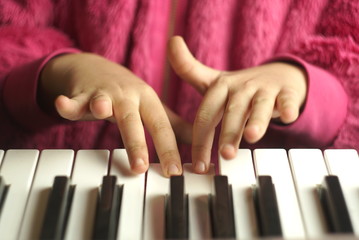 Keyboard Electronic Piano And Playing Child Hands.
