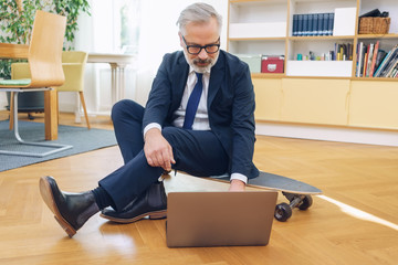 Sporty businessman working on a skateboard