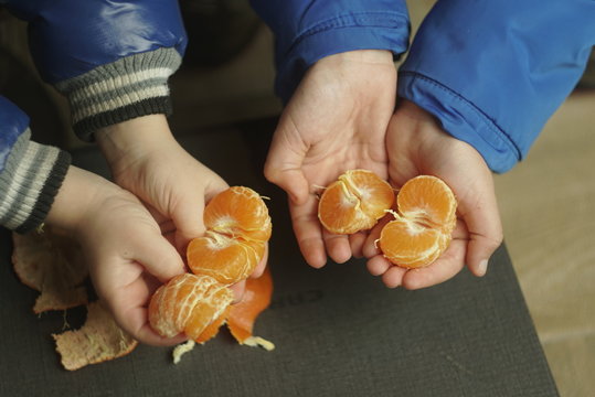 Tangerines are cleaned in the hands of children