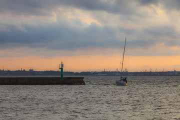 Fototapeta premium Yacht returns back to the pier at sunset