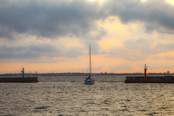 Yacht returns back to the pier at sunset