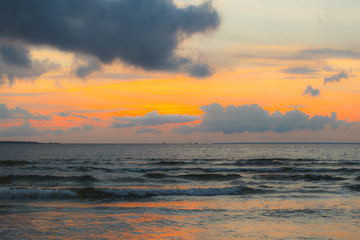 Calm Baltic sea at sunset with beautiful clouds and low waves