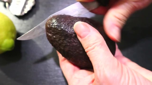 avocado in a hand of woman. cuts avocad