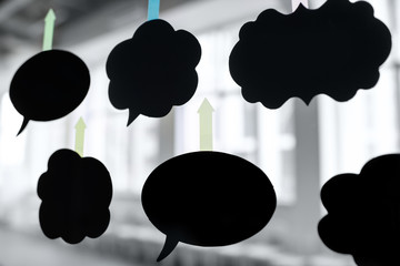 Black stickers in form of clouds with empty space on the glass wall in the office