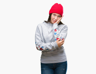 Young caucasian beautiful woman wearing wool cap over isolated background thinking looking tired and bored with depression problems with crossed arms.