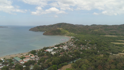 Fototapeta na wymiar Aerial view of coast with beach, hotels. Philippines, Luzon. Coast ocean with tropical beach, turquoise water. Tropical landscape in Asia.