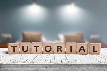 Tutorial sign on a wooden table in a room with lights - obrazy, fototapety, plakaty