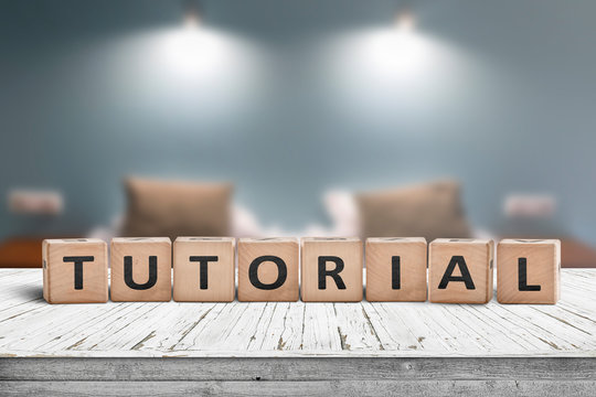 Tutorial sign on a wooden table in a room with lights