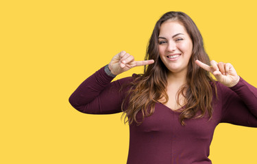 Fototapeta premium Beautiful and attractive plus size young woman wearing a dress over isolated background smiling confident showing and pointing with fingers teeth and mouth. Health concept.