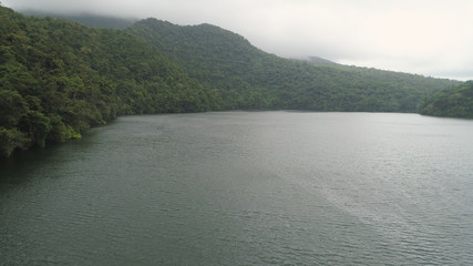 Aerial view of lake Bulusan in the mountains with green rain forest. Lake hidden in the jungle mountains near the volcano Bulusan. Tropical landscape with forest and lake. Philippines, Luzon