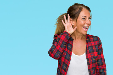 Middle age adult woman wearing casual jacket over isolated background smiling with hand over ear...