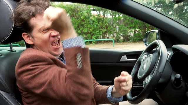 Happy man in car feeling successful making funny moves