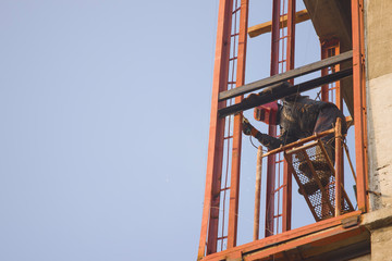 Welder work at a height in the building under construction.