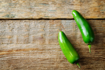 Fresh jalapeno peppers on a dark wood background