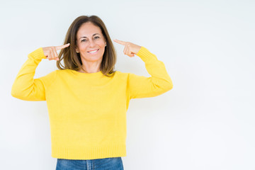 Obraz na płótnie Canvas Beautiful middle age woman wearing yellow sweater over isolated background Smiling pointing to head with both hands finger, great idea or thought, good memory