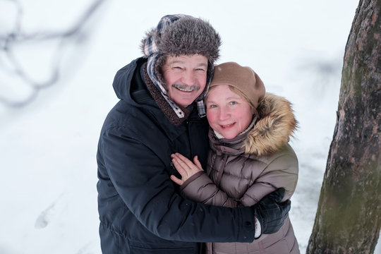 Portrait Of Elderly Couple Having Fun Outdoors In Winter Forest