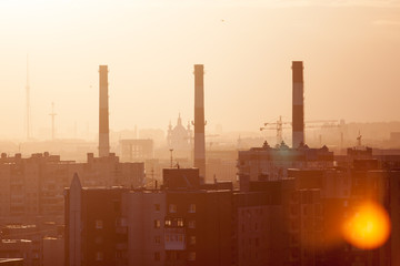 Fototapeta na wymiar Three chimneys at sunset, city landscape