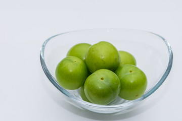 The small turkish green plums in the glass bowl