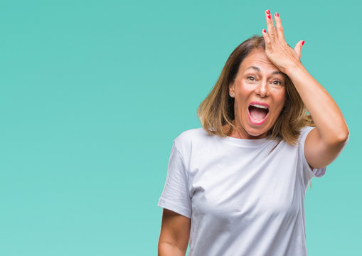 Middle age senior hispanic woman over isolated background surprised with hand on head for mistake, remember error. Forgot, bad memory concept.