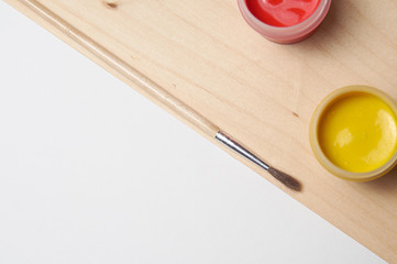 Preparation for the designer. White sheet and paint on wood background.