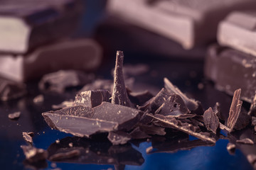 Chocolate chips and pieces of dark bitter chocolate close-up, macro shot