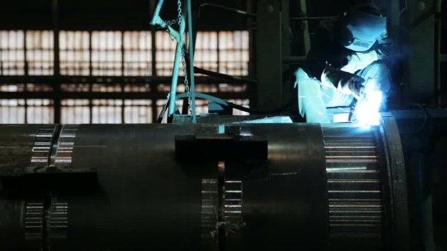 Welder welding metalwork in a factory