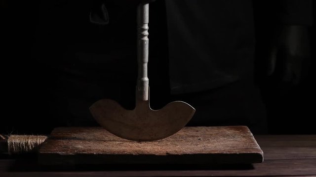 chef in black clothes holds in his hand a metal old knife for meat and vegetables