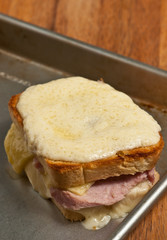 Top, front view, close distance of a freshly prepared, fried egg being on the croque madame on a baking tin 